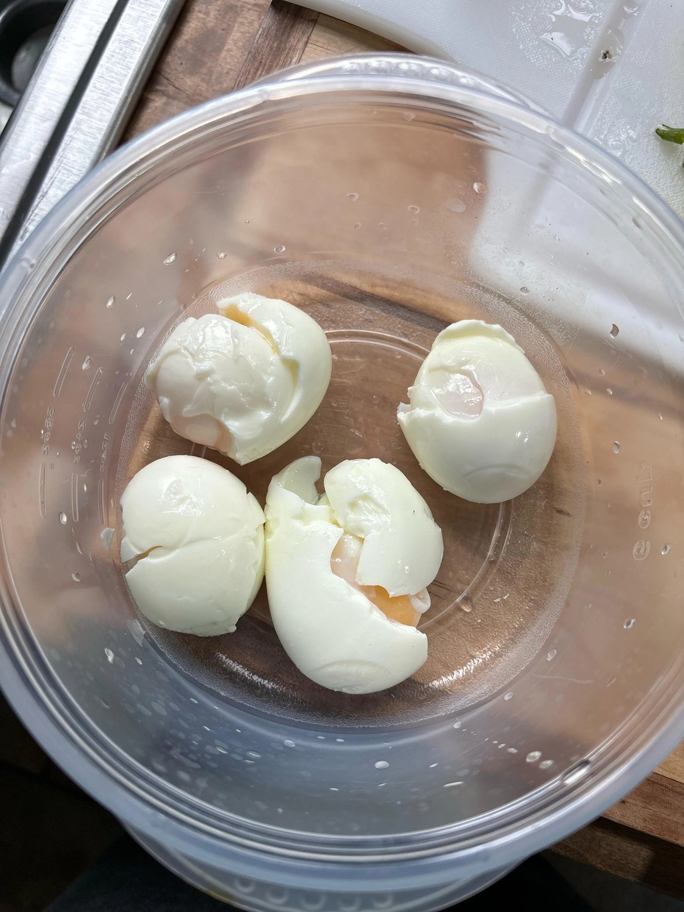 Torn, partly peeled boiled eggs in a glass bowl