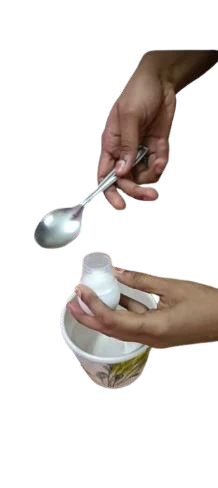 A spoon about to tap the capped egg held over a bowl
