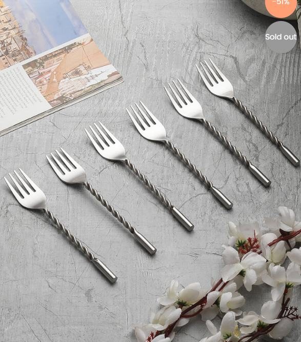Silver forks with twisted handles on a grey surface