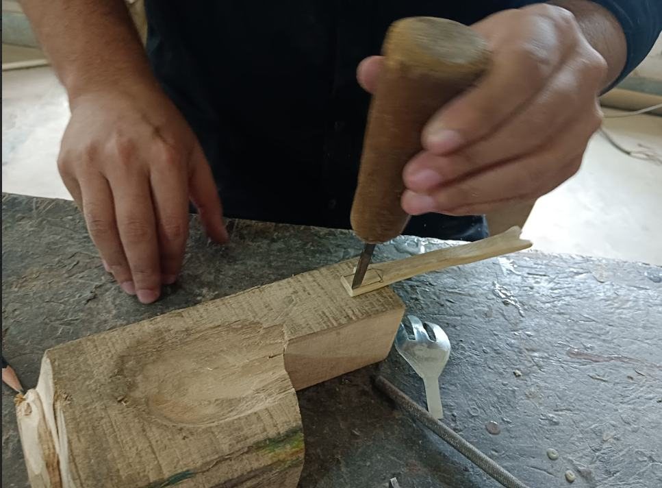 Carving a spoon-shaped hollow into a wooden mold