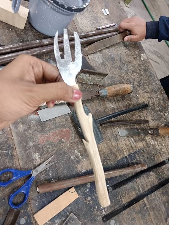 A fork with a wooden handle held in a hand