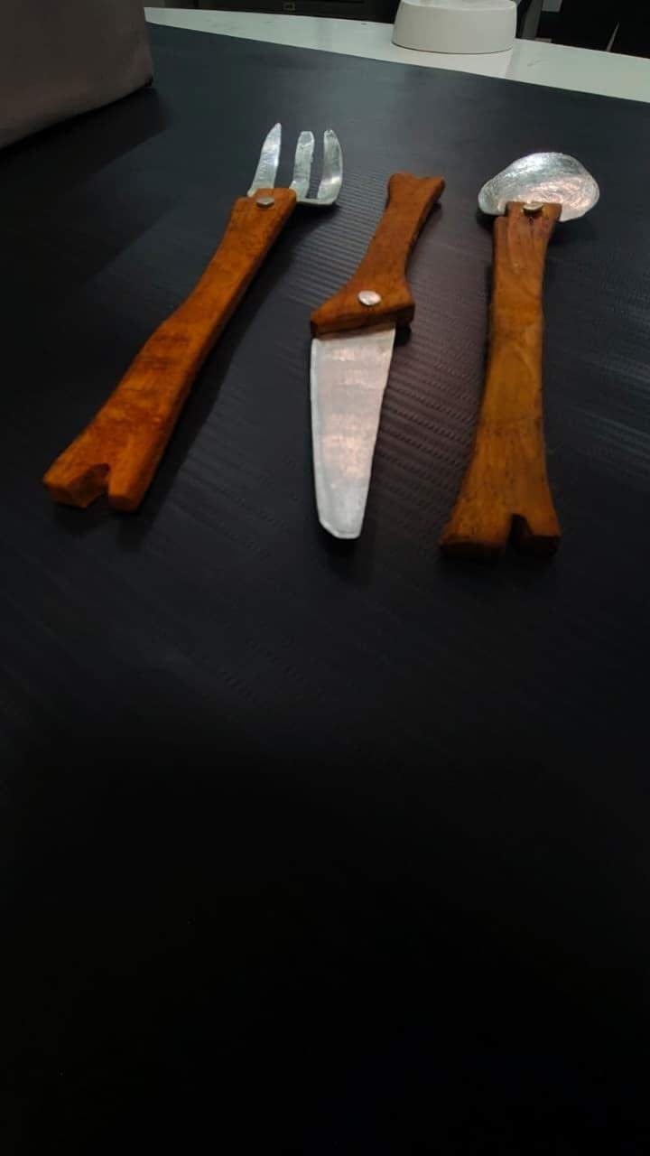 Fork, knife and spoon with orange handles, seen from above