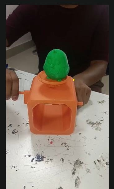 The assembled orange automata with a green bird, held in hands
